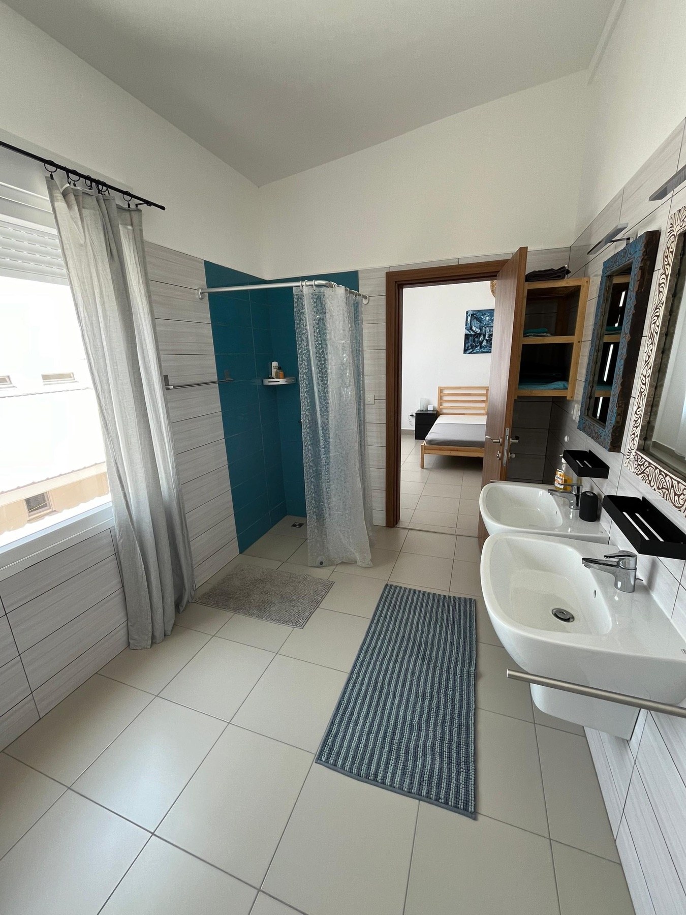 Großes helles Badezimmer mit zwei Waschbecken und Dusche